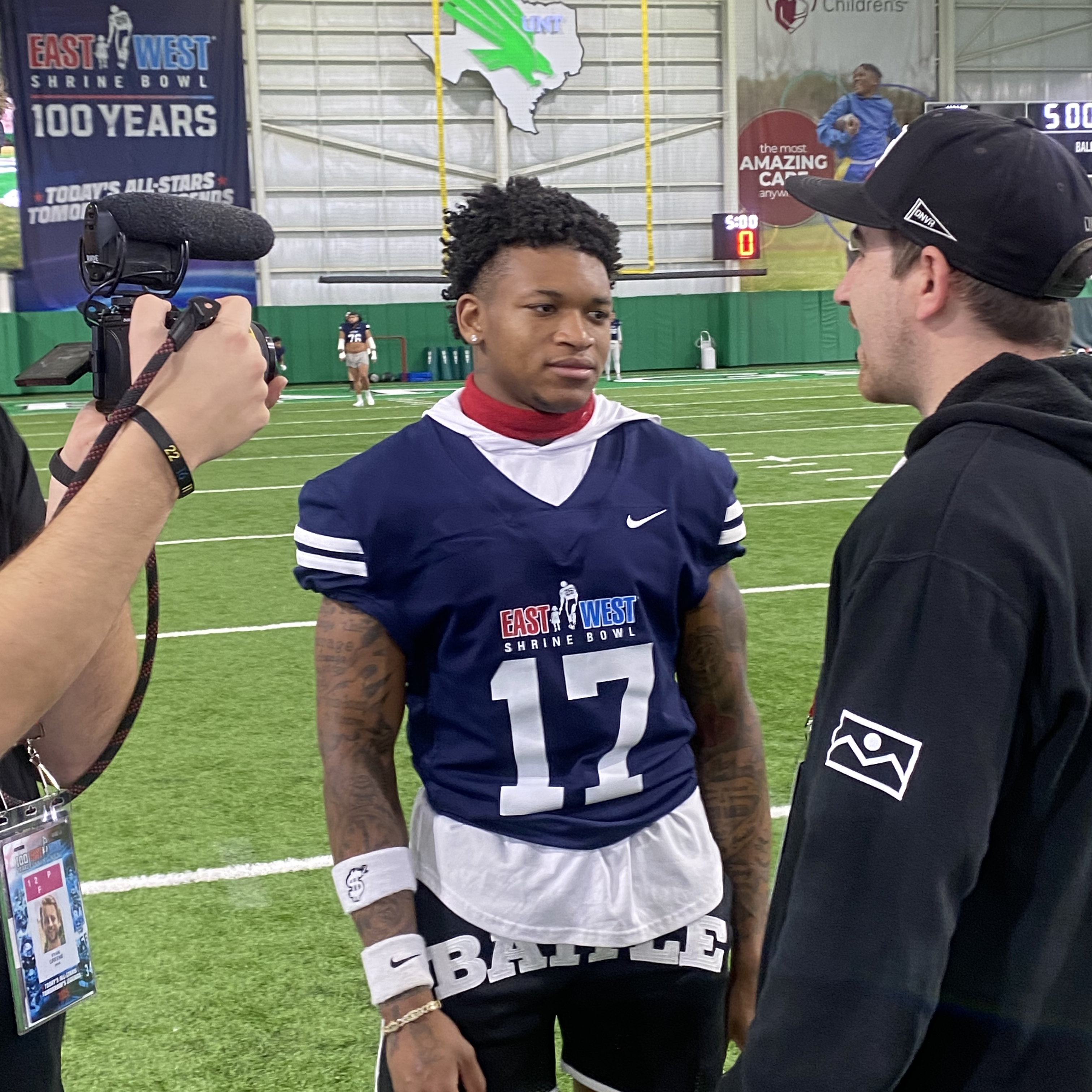 interview A young man in a football jersey being interviewed by the media